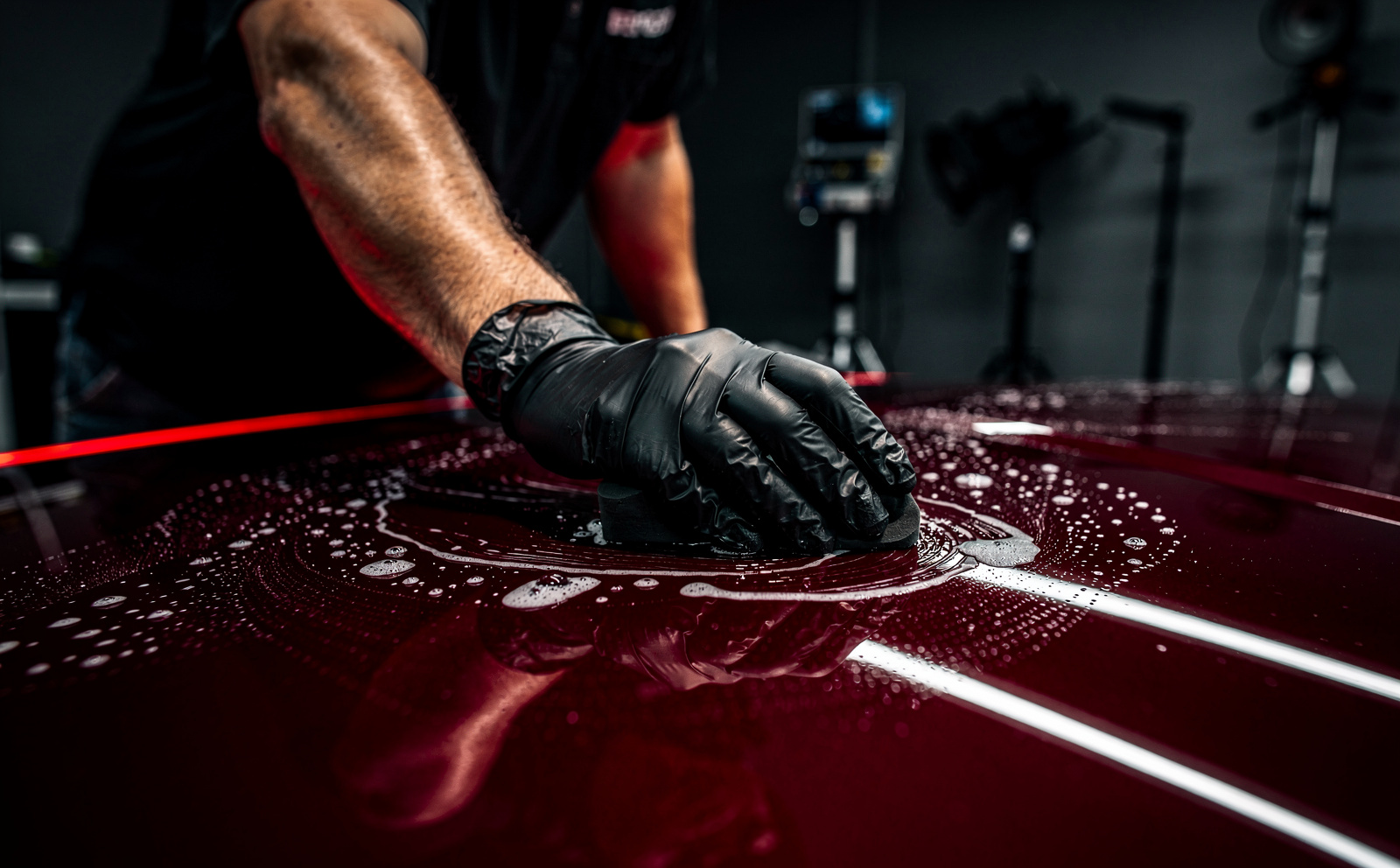 Technician decontaminating paint before PPF installation